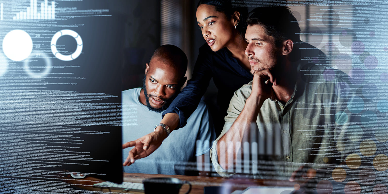 Team of co-workers looking at a computer monitor, with digital code and graphics in the foreground.